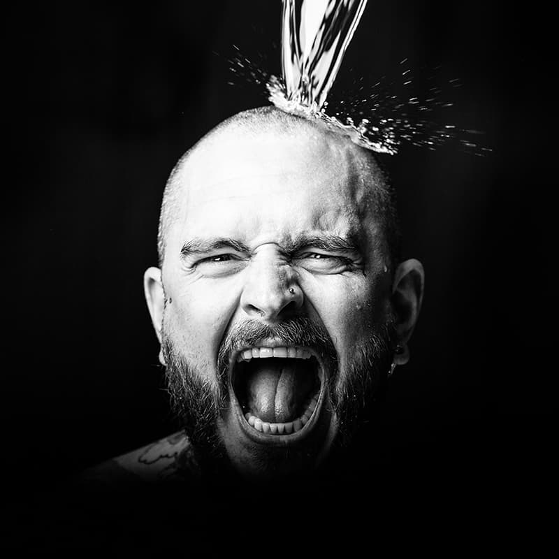 Portrait of a mans head with water splashing on it