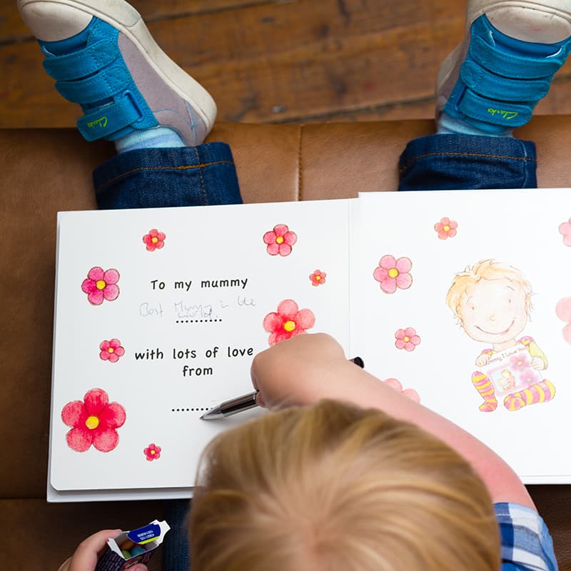 Over head shot of a child writing in a book.