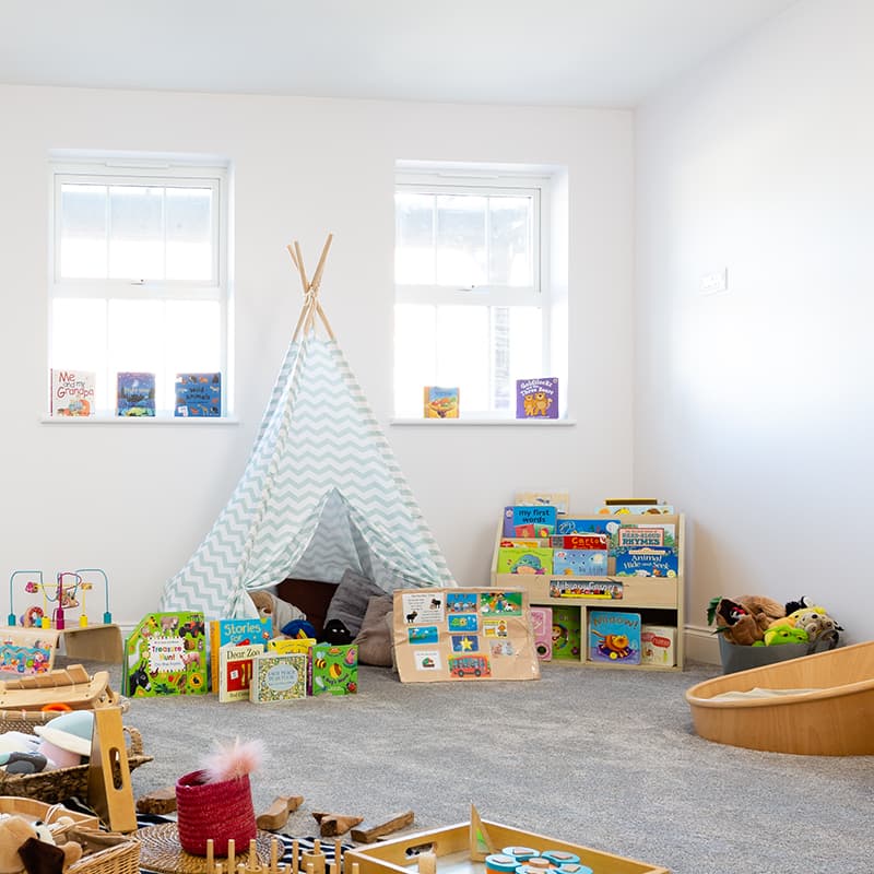 Childs blue and white Teepee in a play room at a nursery.